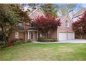 Charming two-story brick home with a well-manicured lawn, mature trees, and a two-car garage at 6227 Braidwood Nw Way, Acworth, GA 30101