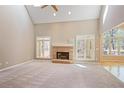 Spacious living room with a brick fireplace, vaulted ceiling, large windows, and neutral carpet at 6227 Braidwood Nw Way, Acworth, GA 30101