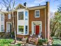 Inviting brick townhome with a red door, manicured landscaping, and charming curb appeal at 1087 High Point Ne Dr, Atlanta, GA 30306