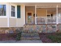 Inviting front porch with a cozy swing and stone accents, creating a charming and relaxing outdoor space at 165 Carriage Gate Dr, Sharpsburg, GA 30277