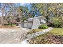 The charming home is surrounded by mature trees and lush greenery at 1507 Fair Haven Dr, Riverdale, GA 30296