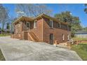 Brick home featuring a staircase leading to an upper level entrance and a long driveway at 2836 Waters Sw Rd, Atlanta, GA 30354
