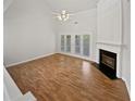 Bright living room with hardwood floors, fireplace, and French doors to the outside at 3905 Delfaire Trce, Cumming, GA 30040