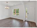 Elegant dining area featuring wainscoting, wood-look floors, and a modern chandelier for stylish meals at 372 Waterbluff Dr, Mableton, GA 30126