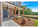 Inviting front porch with decorative pillars, manicured landscaping, and a stylish blue front door at 372 Waterbluff Dr, Mableton, GA 30126