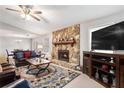 Cozy living room with a stone fireplace, ceiling fan, and plush leather furniture at 787 Faye Nw Dr, Kennesaw, GA 30144