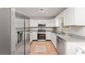 Modern kitchen with stainless steel appliances, granite countertops, tile floors, and white cabinetry at 2485 Field Spring Dr, Stonecrest, GA 30058