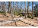 View of the brick home from the driveway, surrounded by trees and greenery at 2696 Dodson Dr, East Point, GA 30344