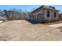 Spacious concrete driveway leading to a two-car garage in a well-kept home with mature trees at 7025 Bavarian Wood Pl, Buford, GA 30518