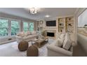 Bright living room with fireplace, built-in shelving and neutral decor at 10835 Tuxford Dr, Alpharetta, GA 30022