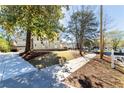 View of the home's side exterior with a well-manicured lawn and mature trees at 585 Sherwood Ne Rd, Atlanta, GA 30324