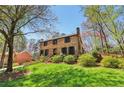 Traditional two-story brick home on a lush lot with mature trees and green grass in a suburban setting at 2411 Mitchell Ne Rd, Marietta, GA 30062