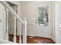 Bright foyer featuring hardwood floors, a glass paneled front door, and white staircase banister at 2411 Mitchell Ne Rd, Marietta, GA 30062
