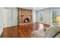 Cozy living room with a brick fireplace, hardwood floors, and large windows letting in natural light at 2411 Mitchell Ne Rd, Marietta, GA 30062