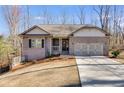 Inviting brick home with a two-car garage boasts a covered porch and well-maintained lawn at 197 Saddleridge Dr, Bremen, GA 30110