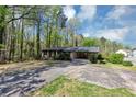 Single-story brick home surrounded by mature trees, with a driveway at 9258 Westview Sw Dr, Covington, GA 30014