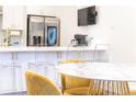 Kitchen area with a stainless steel refrigerator, white cabinetry, and island seating plus marble table at 224 Ormond Sw St # A, Atlanta, GA 30315