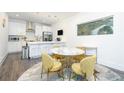 Open kitchen area with stainless steel appliances, island seating, a modern table set, and hardwood floors at 224 Ormond Sw St # A, Atlanta, GA 30315