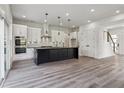 Modern kitchen featuring stainless appliances, a central island, and access to the staircase at 2312 Herring Sw Rd, Atlanta, GA 30311