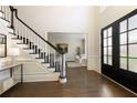 Spacious foyer with dark wood floors, a staircase, and a glimpse into the living area at 315 Chandon Place Ct, Alpharetta, GA 30022