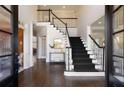 Grand foyer with hardwood floors, a sweeping staircase, and elegant black and white accents at 315 Chandon Place Ct, Alpharetta, GA 30022
