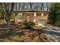 Charming brick home featuring a well-manicured lawn and an attached garage at 4564 Cypress Ridge Ct, Stone Mountain, GA 30083