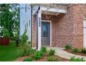 Inviting front entrance with brick facade, gray door, and nicely landscaped garden at 656 Avondale Park Cir, Decatur, GA 30032