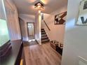 Inviting entryway with modern light fixture, staircase, bench seating, and decorative wall art at 376 Eagle Tiff Dr, Sugar Hill, GA 30518