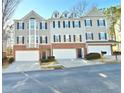 Townhome exterior with a brick facade, siding, and attached garages nestled on a street with well-maintained landscaping at 376 Eagle Tiff Dr, Sugar Hill, GA 30518