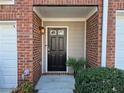 Close-up of a welcoming front door framed by brick and siding with lush landscaping at 376 Eagle Tiff Dr, Sugar Hill, GA 30518