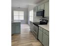 Modern kitchen featuring stainless steel appliances, quartz countertops, and light wood flooring at 145 Berkshire Dr, Covington, GA 30016