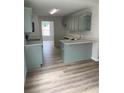 Bright kitchen with light wood floors, quartz countertops, and modern stainless-steel appliances at 145 Berkshire Dr, Covington, GA 30016