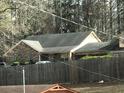 Brick home with dark roof and a wooden fence at 5100 Alexander Ave, Union City, GA 30291