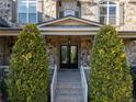 Inviting stone facade entrance featuring a double door entry and manicured shrubs at 12640 Hearthstone Way, Alpharetta, GA 30009