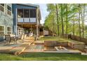 Expansive backyard featuring a deck, outdoor seating, putting green and inviting fire pit at 551 Rokeby Dr, Woodstock, GA 30188