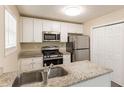 Bright kitchen featuring granite countertops, stainless steel appliances, and updated fixtures at 1059 Buckboard Ct, Douglasville, GA 30134