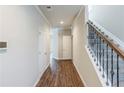 Inviting hallway with hardwood floors, white doors, staircase with decorative iron spindles at 169 Parkview Place Dr, Mcdonough, GA 30253