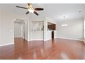 Open-concept living area with hardwood floors, ceiling fan, and kitchen view at 5895 Sheppard Dr, Cumming, GA 30040