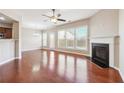 Spacious living room with hardwood floors, a fireplace, and large windows at 5895 Sheppard Dr, Cumming, GA 30040