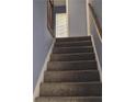 Carpeted stairs leading to the upper level with wood railing and natural light at 851 Hedge Garden Ct, Stone Mountain, GA 30088