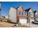 Brick and siding townhome with a two-car garage and a neatly maintained lawn at 1042 Edwin Ln, Sugar Hill, GA 30518