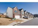 Row of modern brick and siding townhomes with two-car garages and well-kept lawns at 1042 Edwin Ln, Sugar Hill, GA 30518