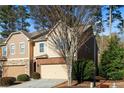 An exterior side-angle showcasing a two-story townhouse with brick, siding, and an attached garage at 1570 Lenox Overlook Ne Rd, Atlanta, GA 30329