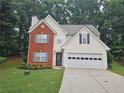 Charming two-story home with brick facade, light siding, manicured lawn, and a two-car garage at 1822 Hayden Mill Ct, Lawrenceville, GA 30043