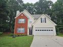 Charming two-story home with brick facade, light siding, manicured lawn, and a two-car garage at 1822 Hayden Mill Ct, Lawrenceville, GA 30043