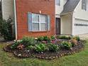 Landscaped flower bed with colorful blooms accentuates the brick facade and light siding of this home at 1822 Hayden Mill Ct, Lawrenceville, GA 30043
