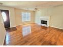 Bright living room featuring hardwood floors, fireplace, and large window at 1822 Hayden Mill Ct, Lawrenceville, GA 30043