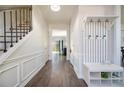 Inviting foyer featuring hardwood flooring, staircase with iron railing, and decorative coat rack with bench seating at 3876 Toccoa Falls Dr, Duluth, GA 30097