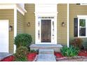 Welcoming front entrance with a classic door, sconce lighting, and decorative landscaping with red mulch at 3876 Toccoa Falls Dr, Duluth, GA 30097