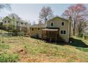 Backyard view of the two-story home with deck and landscaping at 494 Rue Montaigne, Stone Mountain, GA 30083